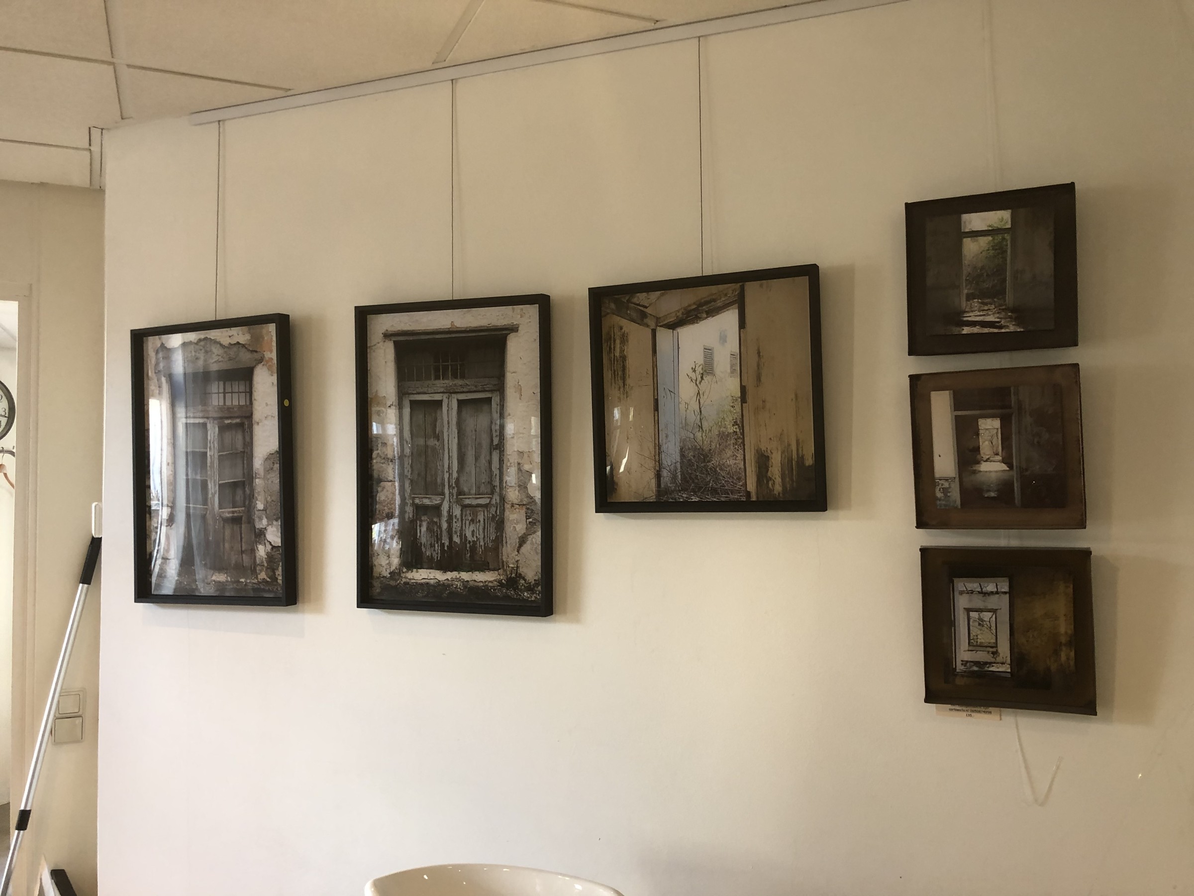 Een overzicht van ingelijste werken aan de wand van een expositieruimte.